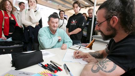 Au festival Quai des Bulles de Saint-Malo, le dessinateur Coyote (&agrave; droite) d&eacute;dicace un de ses albums de bande dessin&eacute;e, le 29 octobre 2005. (MAXPPP)