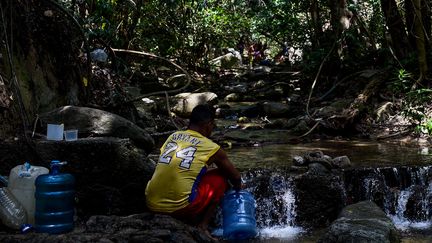 Un homme vient s'approvisonner en eau dans la montagne Avila qui surplombe Caracas (Venezuela) le 13 mars 2019. (FEDERICO PARRA / AFP)