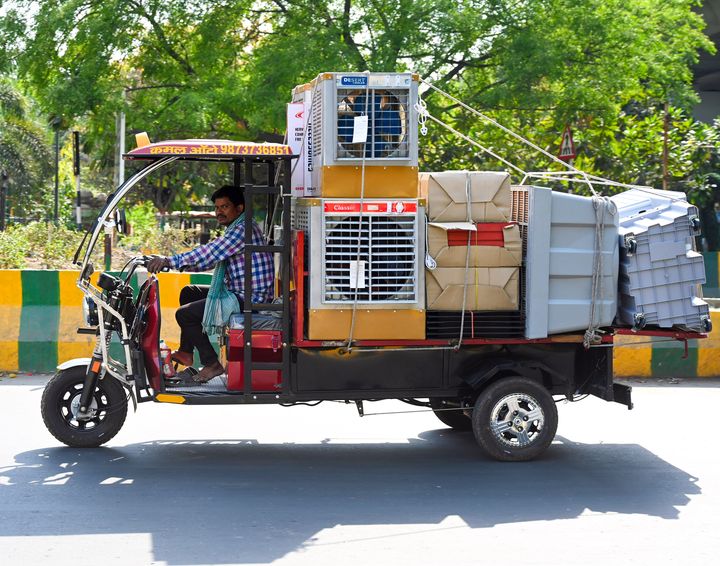 Un homme transporte des refroidisseurs d'air le 10 avril 2024 à Noida, en Inde.  (SUNIL GHOSH / TEMPS HINDUSTAN / GETTY IMAGES)