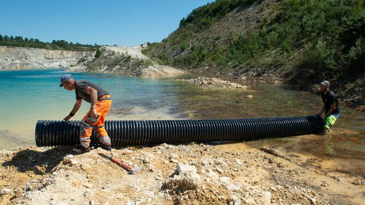 Des ouvriers raccordent la commune de Berrien (Finistère) à une ancienne carrière de kaolin, le 11 août 2022. (ALICE MOUCHARD / MAXPPP)