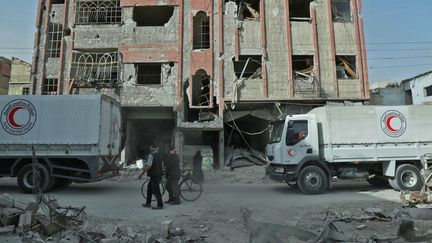 Des camions du Croissant rouge syrien, transportant de l'aide humanitaire, le 5 mars 2018, à Douma en Syrie. (HAMZA AL-AJWEH / AFP)