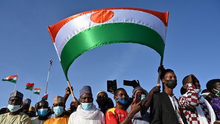 Des ressortissants nigériens attendent l'arrivée du président nigérien à l'aéroport de Ouagadougou dans le cadre de sa visite officielle au Burkina Faso, le 17 octobre 2021. Photo d'illustration. (ISSOUF SANOGO / AFP)