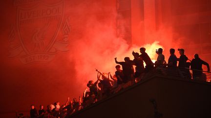 Des supporters de Liverpool fête le tire de leur club, le 26 juin 2020. (OLI SCARFF / AFP)