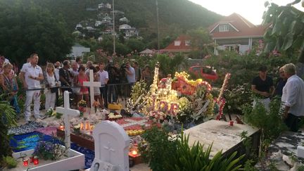 Les fans se recueillent sur la tombe de Johnny Hallyday au cimetière de Lorient à Saint-Barthélémy, le 5 décembre 2018. Un autre caveau est en projet à l'initiative de Laeticia Hallyday. (VALENTINE AUTRUFFE / AFP)