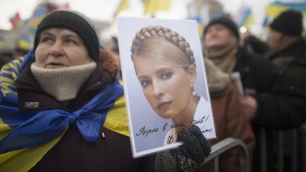 Une opposante brandit un portrait de l'ex-Premi&egrave;re ministre Ioulia Timochenko, &agrave; Kiev (Ukraine), le 8 d&eacute;cembre 2013. (ILIYA PITALEV / RIA NOVOSTI / AFP)