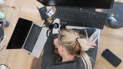 Une femme couchée sur un bureau (illustration). (VANESSA MEYER / MAXPPP)