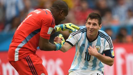 Le gardien nig&eacute;rian Vincent Enyeama aide l'Argentin Lionel Messi &agrave; se relever, le 25 juin 2014, lors d'un match de Coupe du monde, &agrave; Porto Alegre (Br&eacute;sil). (PEDRO UGARTE / AFP)