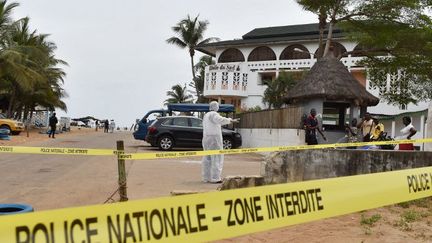 Un policier marche devant l'Hôtel Etoile du Sud à Grand-Bassam, en Côte d'Ivoire le 14 mars 2016, au lendemain de l'attaque revendiquée par le groupe terroriste Aqmi. 

 (ISSOUF SANOGO / AFP)