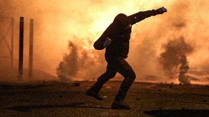 Un manifestant s'apprête à jeter un projectile lors de la manifestation en soutien à Yvan Colonna, le 13 mars 2022 à Bastia (Haute-Corse). (PASCAL POCHARD-CASABIANCA / AFP)