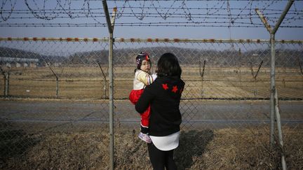 Une femme tient sa fille dans ses bras à la frontière entre la Corée du sud et la Corée du nord (KIM HONG-JI / REUTERS)