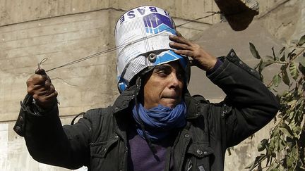 Un manifestant affronte la police avec un lance-pierre pr&egrave;s de la place Tahrir au Caire (Egypte), le 23 novembre 2011. (GORAN TOMASEVIC / REUTERS)