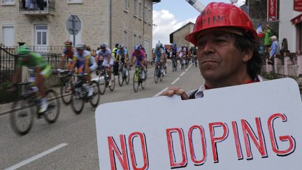 Un spectateur brandit un panneau "Pas de dopage", lors de l'&eacute;tape entre M&acirc;con (Sa&ocirc;ne-et-Loire) et Bellegarde-sur-Valserine (Ain), durant le Tour de France 2012, le 11 juillet 2012. (JOEL SAGET / AFP)