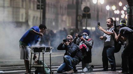 Un &eacute;tudiant pr&eacute;pare un barbecue dans une rue pr&egrave;s de la mairie de Sao Paulo (Br&eacute;sil), le 18 juin 2013. (MIGUEL SCHINCARIOL / AFP)