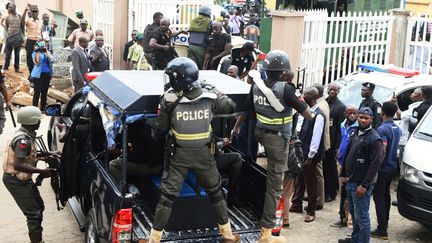 Des policiers anti-émeutes nigérians conduisent en prison un chef présumé d'un kidnapping, après qu'il a été traduit en justice devant la Haute Cour de l'Etat de Lagos, le 30 août 2017.&nbsp; (PIUS UTOMI EKPEI / AFP)