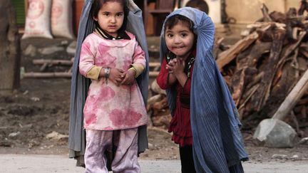 Deux jeunes Afghanes imitent leurs mamans avec des mini&nbsp;burqas &agrave;&nbsp;Jalalabad (Afghanistan), le 17 mars 2013. (RAHMAT GUL / AP / SIPA)