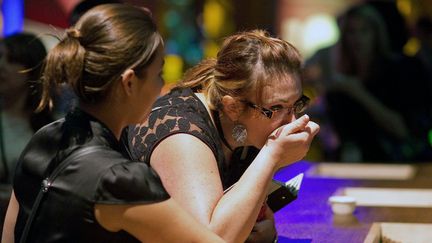 Deux femmes sentent des &eacute;chantillons de graines de caf&eacute; lors d'un &eacute;v&egrave;nement organis&eacute; par l'entreprise Starbucks, le 4 octobre 2012 &agrave; Houston, au Texas (Etats-Unis). (BLOOMBERG)