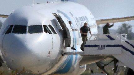 Les derniers occupants de l'avion d'EgyptAir descendent&nbsp;la passerelle sur l'aéroport de Larnaca (Chypre), le 29 mars 2016 (YIANNIS KOURTOGLOU / REUTERS)