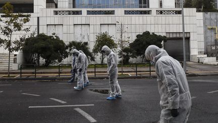 Des experts de la police grecque inspectent les abords de la cour d'appel d'Athènes, le 22 décembre 2017, après l'explosion d'un engin. (ANGELOS TZORTZINIS / AFP)