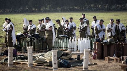 Des soldats isra&eacute;liens prient &agrave; c&ocirc;t&eacute; de l'artillerie, &agrave; la fronti&egrave;re pr&egrave;s de la bande de Gaza, le 21 novembre 2012.&nbsp; (MENAHEM KAHANA / AFP)