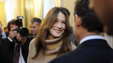 Carla Bruni-Sarkozy discute avec son mari lors de la f&ecirc;te donn&eacute;e pour No&euml;l &agrave; l'Elys&eacute;e (Paris), le 14 d&eacute;cembre 2011. (ERIC FEFERBERG / AFP)