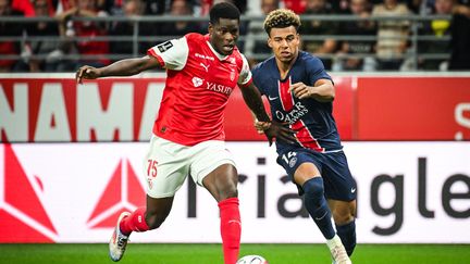 Marshall Munetsi avec Reims et Désiré Doué avec le PSG, le 21 septembre 2024, au stade Auguste-Delaune, dans le cadre de la 5ᵉ journée de Ligue 1. (MATTHIEU MIRVILLE / MATTHIEU MIRVILLE)