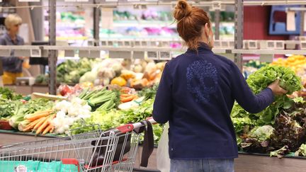 Une cliente en train d'acheter une salade au rayon fruits et légumes d'un supermarché.&nbsp; (JEAN-FRANCOIS FREY / MAXPPP)