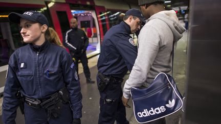 Des policiers contr&ocirc;lent un passager, le 30 novembre 2012, sur un quai de la gare du Nord, &agrave; Paris. (FRED DUFOUR / AFP)