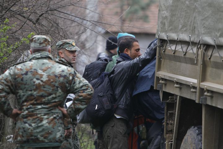 Un migrant monte à bord de l'un des camions de l'armée macédonienne, le 14 mars 2016 à Moini (Macédoine). (OGNEN TEOFILOVSKI / REUTERS)