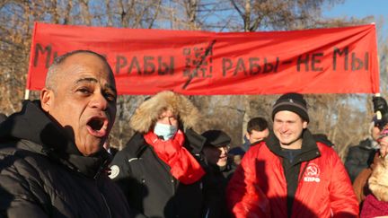 Les personnes participent à une manifestation contre l'introduction du système du pass sanitaire dans un jardin public de la rue Bolshakova, à Yekaterinburg, en Sibérie occidentale. La bannière indique "Nous ne sommes pas des esclaves." (DONAT SOROKIN / TASS)