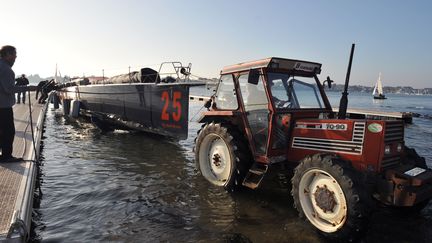 Le bateau "Safran" de Marc Guillemot est remorqu&eacute; hors de l'eau par un tracteur, apr&egrave;s son abandon lors du Vend&eacute;e Globe, le 14 novembre 2012, &agrave; Saint-Philibert.&nbsp; (FRANK PERRY / AFP)