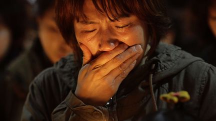 Une femme se recueille lors d'une veill&eacute;e organis&eacute;e le 17 avril 2014 &agrave; Ansan (Cor&eacute;e du Sud),&nbsp;en hommage aux personnes disparues la veille dans le naufrage du ferry "Sewol". (WOOHAE CHO / AP / SIPA)