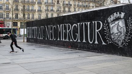 On s'appropie la place, la statue... Jusqu'aux palissades du café en travaux après un incendie. "Fluctuat nec mergitur" (Il est battu par les flots, mais ne sombre pas), la devise de Paris, y est taguée. (ROLLINGER-ANA / ONLY FRANCE / AFP)