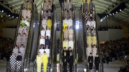 Louis Vuitton a créé l’évènement avec un hommage appuyé à sa toile Damier. C’est Daniel Buren qui signe la scénographie du show à travers une mise en scène géométrique spectaculaire. Les mannequins descendent et montent au gré d’escalators en mouvement qui les déposent sur un podium en damier jaune citron et blanc format XXL. Défilant deux par deux, les filles portent des vêtements, aux coupes précises, au motif Damier que Marc Jacobs revisite avec chic.
 (Martin Bureau /AFP)