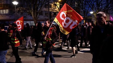 Un manifestant tient un drapeau de la CGT lors d'une manifestation à Lille, le 17 mars 2023. (SAMEER AL-DOUMY / AFP)