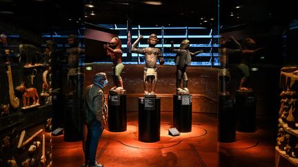 Un visiteur regarde une&nbsp;partie des trésors royaux d'Abomey présentés au musée du quai Branly à Paris, en septembre 2021. (CHRISTOPHE ARCHAMBAULT / AFP)