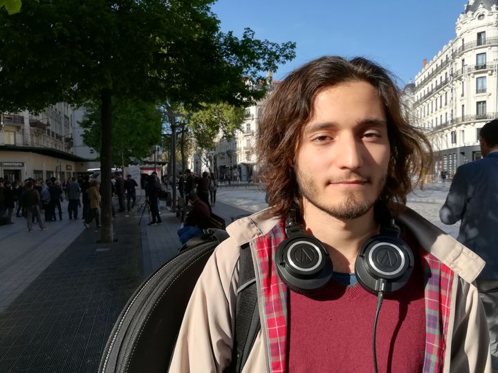 Maël, un&nbsp;étudiant en musicologie et en sciences, s'est arrêté pour écouter Jacques Cheminade, place de la République, à Lyon, le 11 avril 2017. (HUGO CAILLOUX / FRANCEINFO)