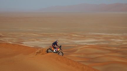 L'Australien Toby Price (KTM) au sommet d'une dune en plein cœur de l'Empty Quarter (Arabie saoudite), à l'occasion de la 12e étape du Dakar, le 13 janvier 2023. (FLORENT GOODEN / AFP)