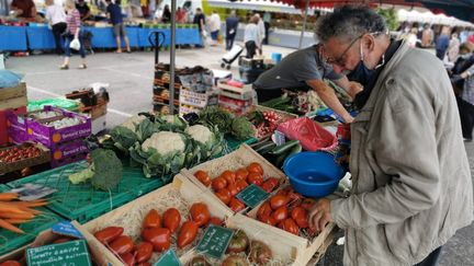 Un homme choisit des fruits et légumes sur un marché de&nbsp;Bourgoin-Jallieu&nbsp;(Isère), le 26 juin 2021. (MAXPPP)