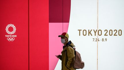 Un homme devant le logo des JO à Tokyo en mars 2020.&nbsp; (PHILIP FONG / AFP)