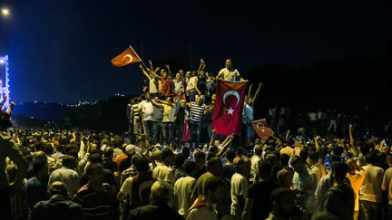 Des manifestants sur un pont à Istanbul (Turquie) pour protester contre le coup d'Etat de certains militaires, le 16 juillet 2016. (GURCAN OZTURK / AFP)