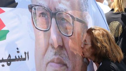 Une manifestante embrasse le portrait de l'écrivain assassiné, Nahed Hattar, lors d'un rassemblement de protestation devant le bureau du Premier ministre jordanien le 26 septembre 2016 à Amman. 