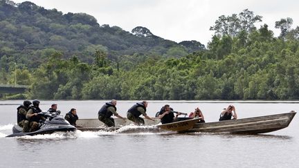 Des militaires et gendarmes participent &agrave; une d&eacute;monstration d'interception de pirogue clandestine, le 16 avril 2009, lors d'une s&eacute;ance d'entra&icirc;nement pour lutter contre l'orpaillage clandestin en Guyane. (JODY AMIET / AFP)