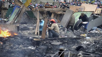 La place de l'ind&eacute;pendance, le Ma&iuml;dan, est un champ de bataille o&ugrave; tout peut se servir &agrave; construire un abri de combat, pneus, planches en bois ou grilles en m&eacute;tal. (LOUISA GOULIAMAKI / AFP)