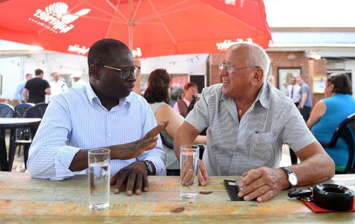 Le député Karamba Diaby discute avec un retraité à Landsberg (Saxe-Anhalt) le 8 août 2017. (HENDRIK SCHMIDT / DPA / AFP)