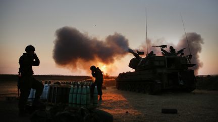 Un char de l'arm&eacute;e isr&eacute;alienne ouvrant le feu sur la bande de Gaza, le 21 juillet 2014. (MENAHEM KAHANA / AFP)