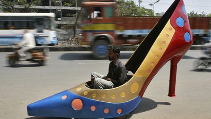 Un employ&eacute; teste une voiture en forme d'escarpin sur une route d'Hyderabad (Inde), le 7 mars 2012. (KRISHNENDU HALDER / REUTERS)