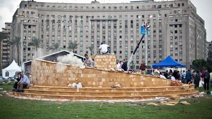 Des ouvriers &eacute;rigent au centre de la place Tahrir au Caire (Egypte) un m&eacute;morial d&eacute;di&eacute; aux victimes des affrontements qui se sont d&eacute;roul&eacute;s cette ann&eacute;e entre l'opposition et les forces de l'odre, le 17 novembre 2013. (VIRGINIE NGUYEN HOANG / AFP)