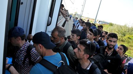 Des migrants montent &agrave; bord d'un train dans la gare d'Ilaca (Croatie), le 17 septembre 2015. (ELVIS BARUKCIC / AFP)