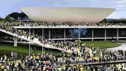 Des partisans de l'ancien président brésilien Jair Bolsonaro, lors de leur assaut contre plusieurs lieux de pouvoir à Brasilia, le 8 janvier 2023. (MIKA OTSUKI / YOMIURI / AFP)