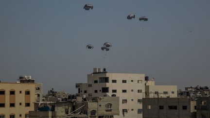 Des colis d'aide humanitaire livrés par parachute dans la bande de Gaza, le 26 mars 2024. (OMAR EL QATTAA / ANADOLU / AFP)